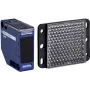 Sensor fotoeléctrico APC XUK1ARCNL2H61 — carcasa de plástico azul, alcance 0–7 m, entrada 24–240 V AC, salida 250 V, 50×50×18 mm